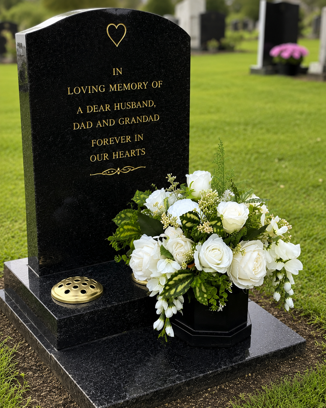 White rose memorial grave pot placed at a graveside on a black granite headstone