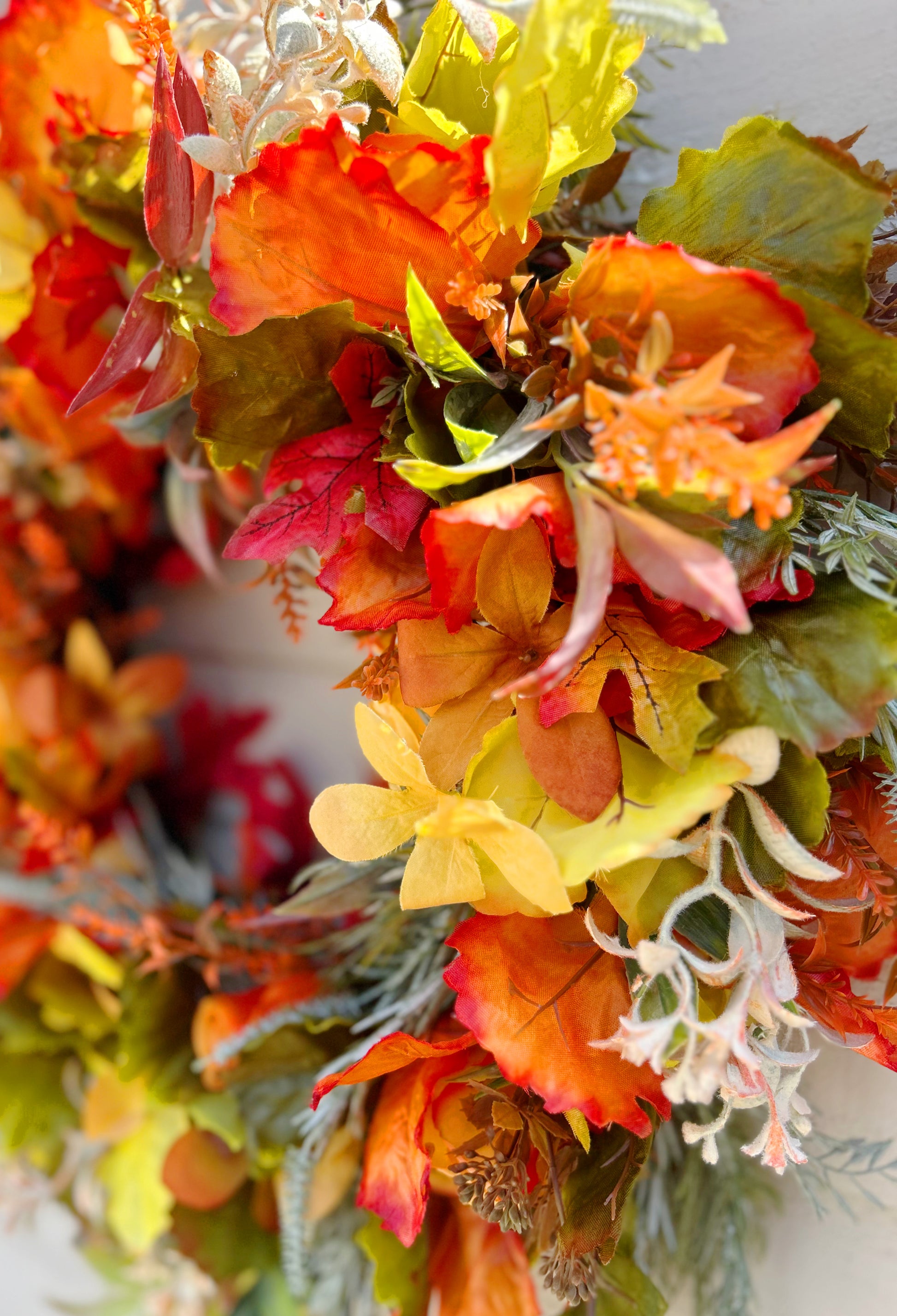 Close up of The Ember wreath showing burnt orange roses and amber hydrangeas